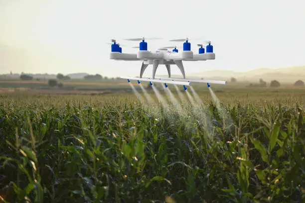 A drone flying over a field, spraying crops - Agristuff