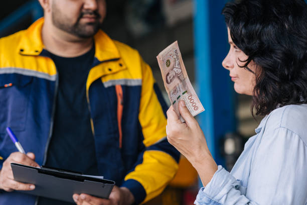 A farmer discussing machinery prices with a dealer, holding a budget - Agristuff