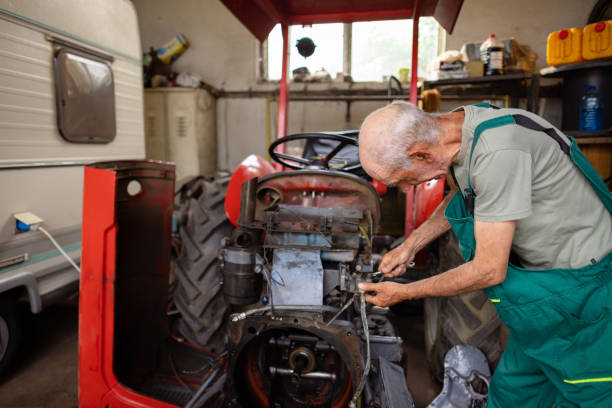 A farmer performing routine maintenance on a tractor, checking oil levels and cleaning the engine.