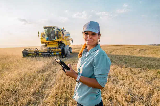 farmer inspecting crops with a modern tractor in the background, showcasing the blend of tradition and technology in agribusiness.